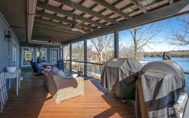 sunroom featuring beam ceiling and ceiling fan