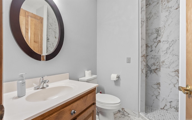 full bath featuring vanity, toilet, marble finish floor, and a tile shower