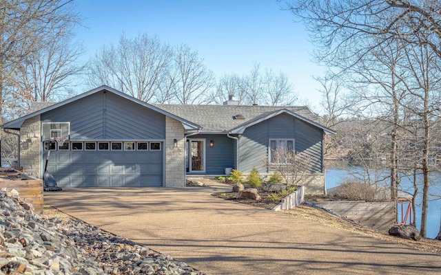 mid-century home with driveway, roof with shingles, an attached garage, a chimney, and stone siding