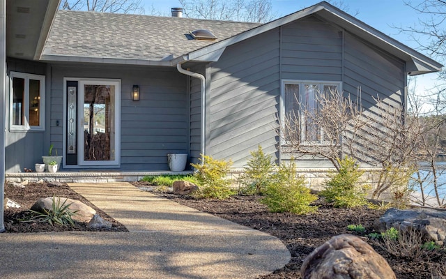 entrance to property with a shingled roof