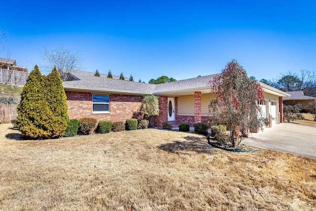 ranch-style house with brick siding, an attached garage, driveway, and a front yard