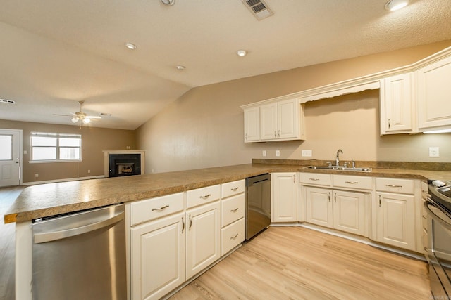 kitchen featuring visible vents, a peninsula, a sink, ceiling fan, and stainless steel appliances