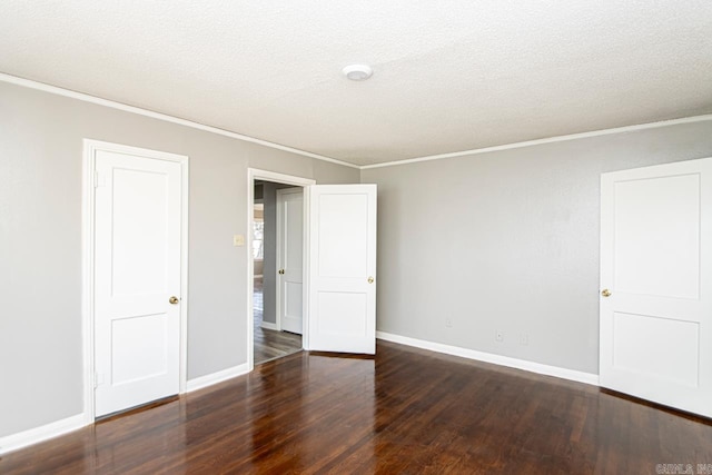 unfurnished room with a textured ceiling, crown molding, baseboards, and wood finished floors