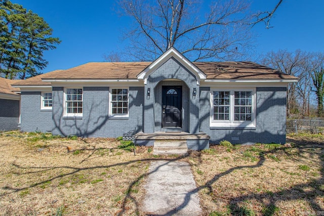 view of front facade with brick siding and fence