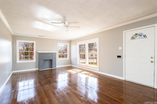 unfurnished living room with crown molding, baseboards, ceiling fan, a fireplace, and wood finished floors