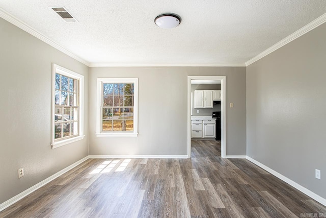 unfurnished room with a textured ceiling, dark wood-style floors, visible vents, and baseboards