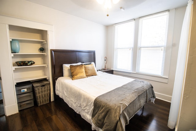 bedroom with dark wood-type flooring and baseboards