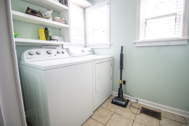 laundry room featuring light tile patterned floors, baseboards, visible vents, laundry area, and washer and clothes dryer