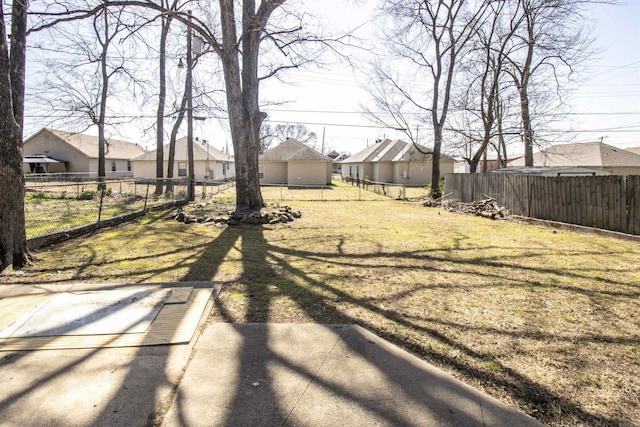 view of yard featuring a residential view, a patio, and a fenced backyard