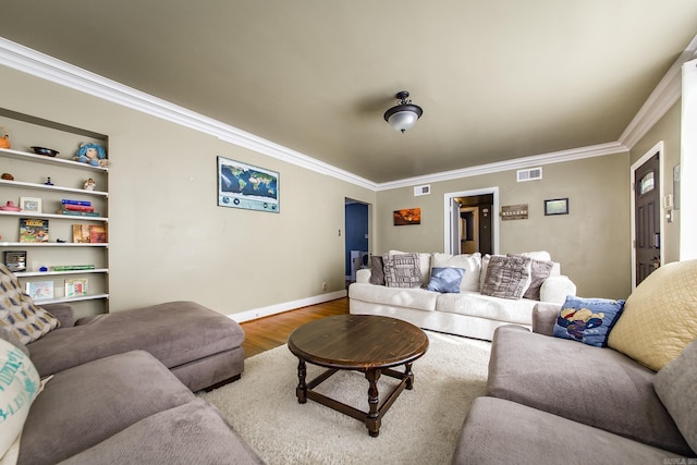 living area featuring visible vents, baseboards, wood finished floors, and crown molding