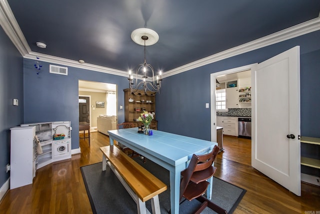 dining area featuring dark wood finished floors, visible vents, crown molding, and a notable chandelier