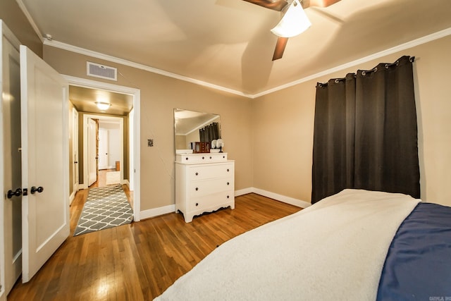 bedroom with visible vents, ornamental molding, and wood finished floors