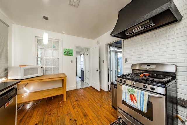 kitchen featuring visible vents, stainless steel appliances, wood-type flooring, extractor fan, and a healthy amount of sunlight