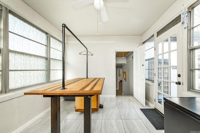 dining space with baseboards and a ceiling fan