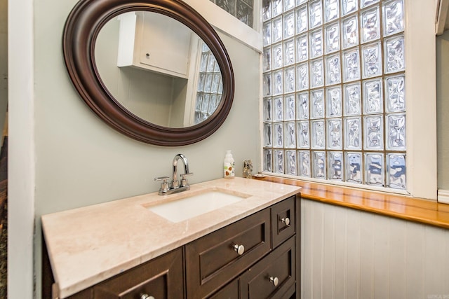 bathroom with a wainscoted wall and vanity