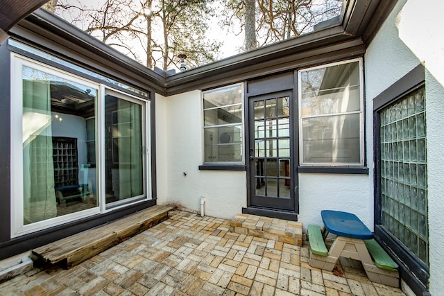 entrance to property featuring stucco siding and a patio