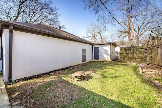 view of yard featuring an outbuilding, a storage unit, and fence