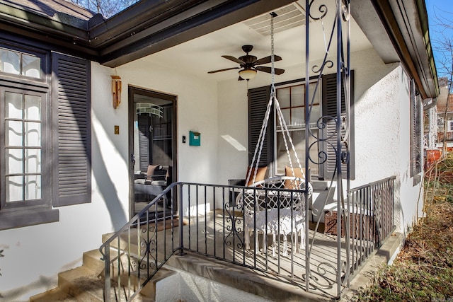 doorway to property with a ceiling fan and stucco siding