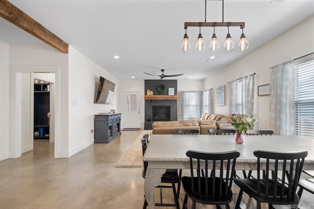 dining room featuring a ceiling fan, finished concrete flooring, baseboards, recessed lighting, and a fireplace