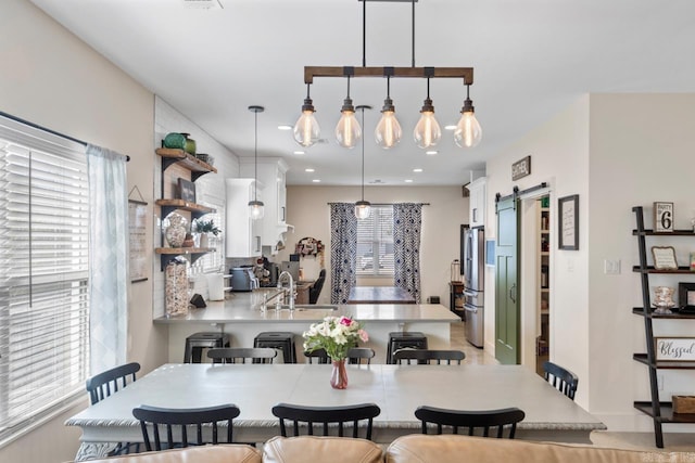 dining room with recessed lighting and a barn door