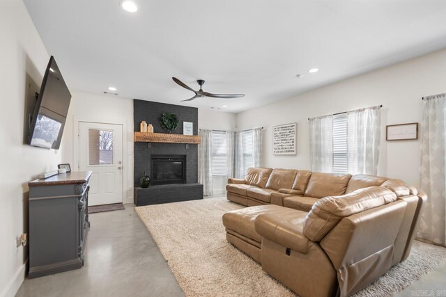 living room featuring recessed lighting, finished concrete floors, a fireplace, and ceiling fan