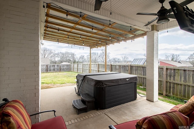 view of patio with a fenced backyard, a hot tub, and a ceiling fan