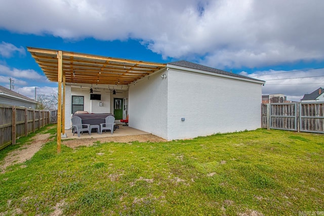 rear view of property featuring ceiling fan, a lawn, a fenced backyard, and a patio area