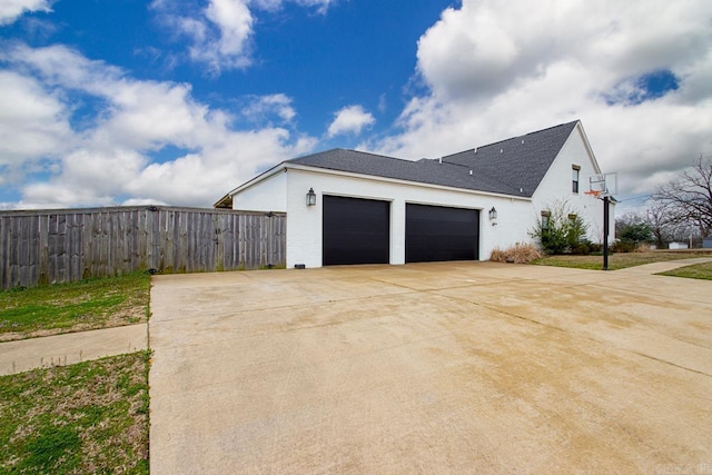 garage with fence and driveway