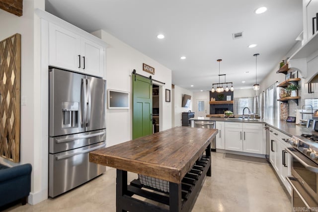 kitchen featuring visible vents, white cabinets, appliances with stainless steel finishes, and a peninsula