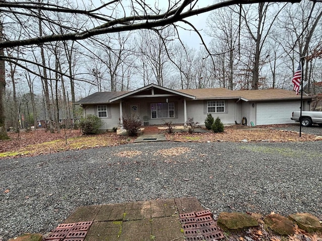 view of front of home featuring covered porch, driveway, and a garage