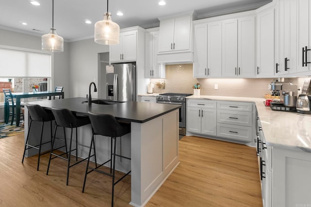 kitchen with a sink, ornamental molding, light wood-style floors, and stainless steel appliances