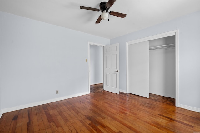 unfurnished bedroom featuring hardwood / wood-style floors, baseboards, a closet, and ceiling fan