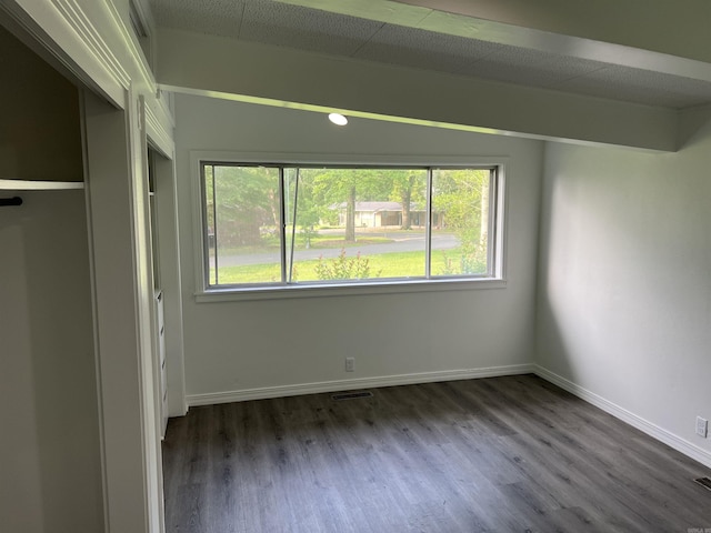 unfurnished bedroom with visible vents, baseboards, and dark wood-style flooring