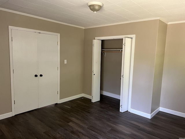 unfurnished bedroom featuring baseboards, dark wood-style floors, and crown molding