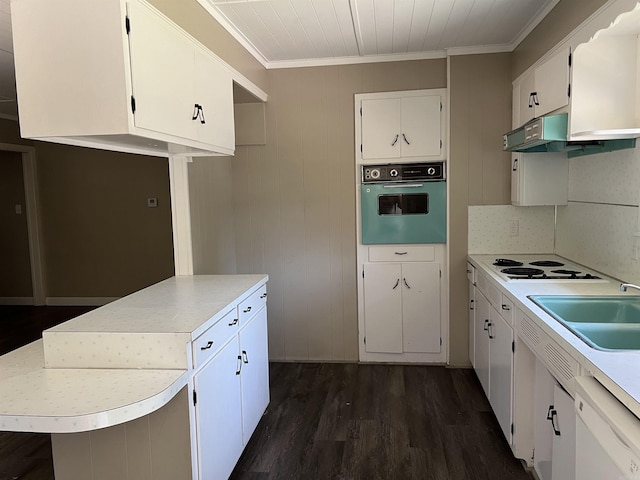 kitchen featuring white appliances, dark wood finished floors, a sink, light countertops, and crown molding