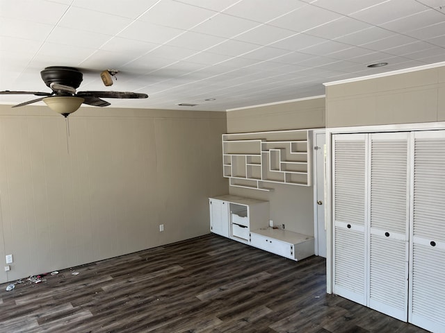 unfurnished bedroom featuring crown molding, dark wood-style floors, a closet, and ceiling fan