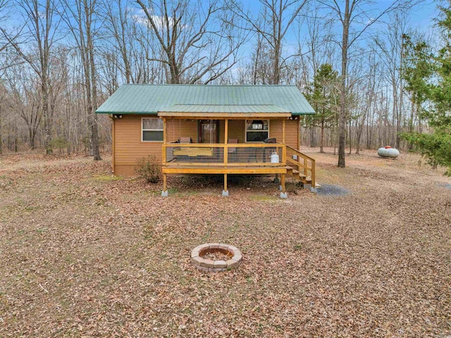 view of front of house featuring a fire pit, a porch, and metal roof