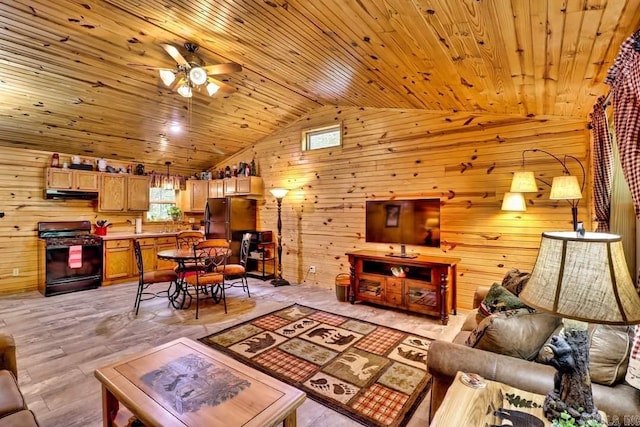 living area featuring lofted ceiling, a ceiling fan, wood walls, and wooden ceiling