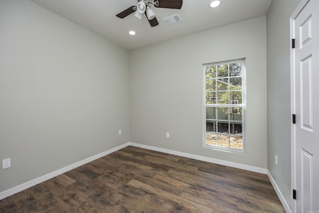 spare room with dark wood-style floors, baseboards, visible vents, and ceiling fan