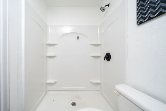 bathroom featuring toilet and a shower