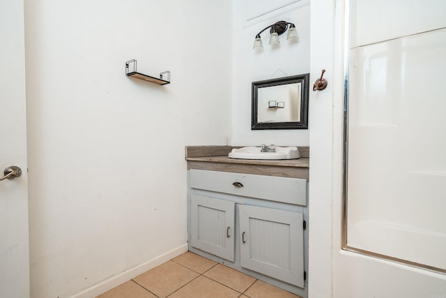 bathroom with tile patterned floors, vanity, and baseboards