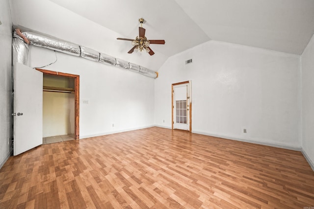 unfurnished bedroom featuring visible vents, baseboards, light wood-type flooring, and lofted ceiling