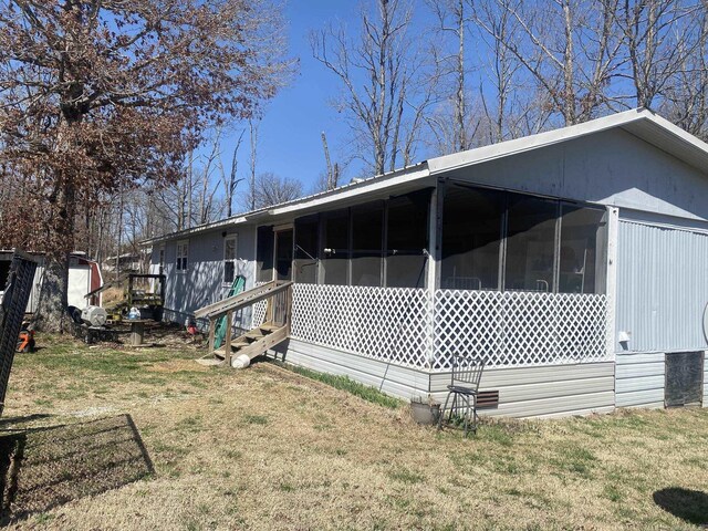 view of side of home with a lawn and a sunroom