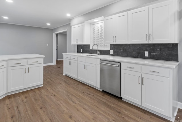 kitchen with tasteful backsplash, dishwasher, light countertops, wood finished floors, and a sink