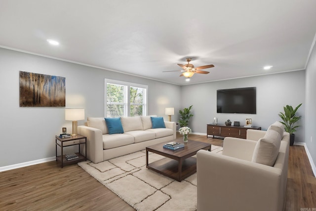 living area with crown molding, light wood-style flooring, and ceiling fan