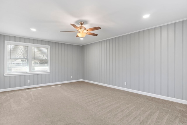 carpeted spare room featuring visible vents, a ceiling fan, recessed lighting, crown molding, and baseboards