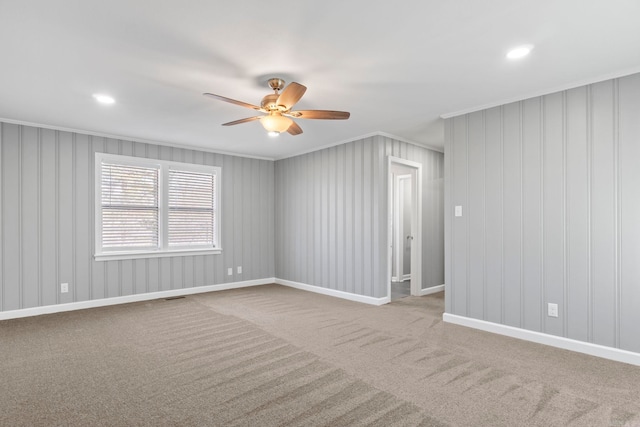 carpeted spare room with a ceiling fan, visible vents, baseboards, recessed lighting, and ornamental molding