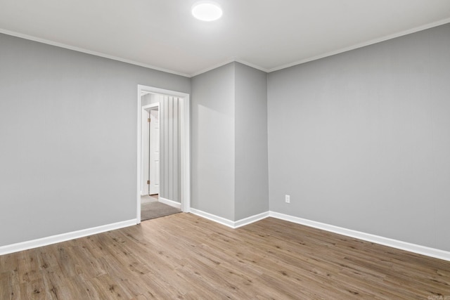 unfurnished room with baseboards, wood finished floors, and crown molding