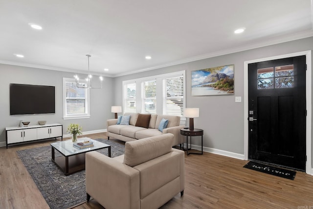 living area with baseboards, a chandelier, ornamental molding, recessed lighting, and wood finished floors