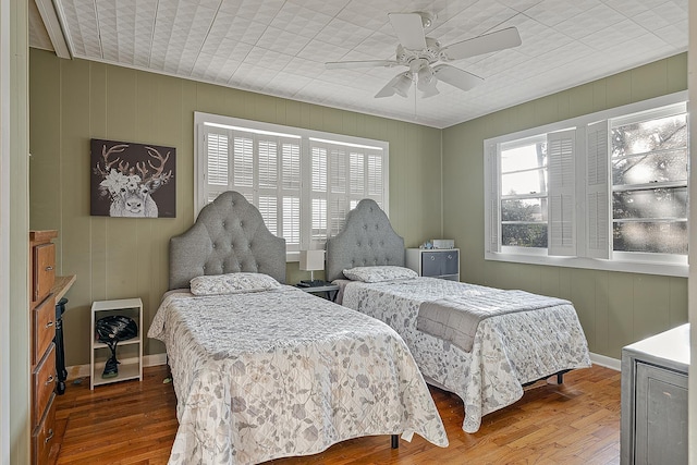 bedroom featuring baseboards, ceiling fan, and wood-type flooring